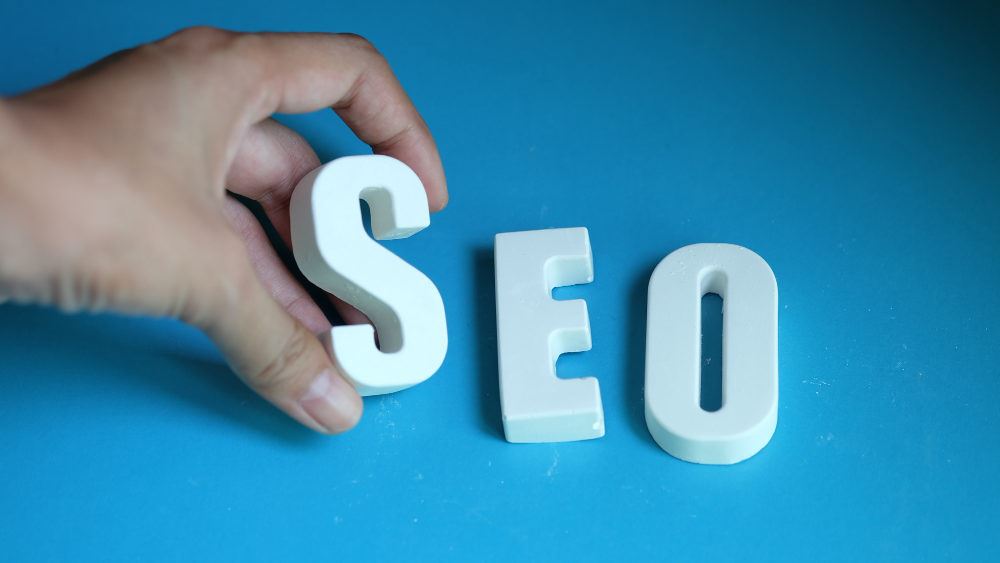 a hand holding the letters S,E, and O that means search engine optimization